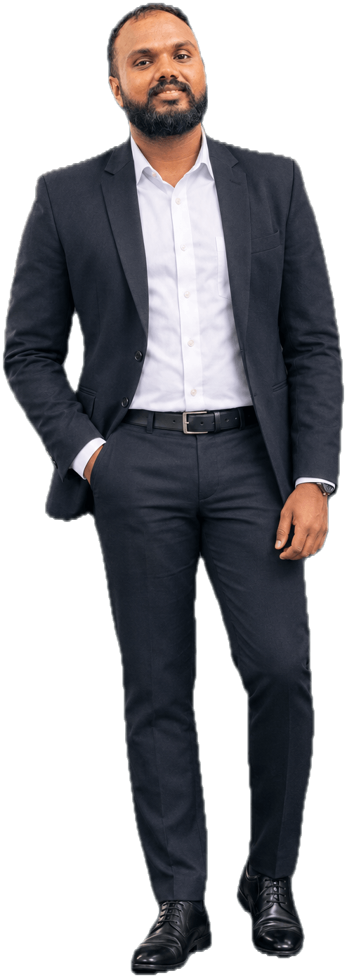 Shiran Hewathennage standing, full length, in a dark suit and white shirt with one hand in his pocket
